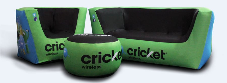 Green and black inflatable furniture set, featuring a sofa, chair, and ottoman adorned with the Cricket Wireless logo. This vibrant inflatable furniture showcases cartoon characters and social media icons, adding a playful touch to any space.