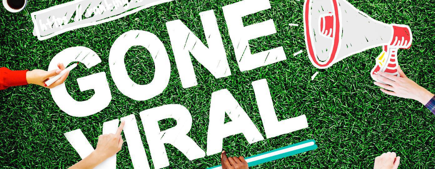 The image shows a green grass background with large white text reading GONE VIRAL. Surrounding the text, four hands are depicted—one holding a smartphone, another clutching a megaphone, and two gesturing as if presenting ideas at a lively marketing event.