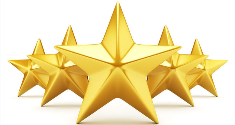 A cluster of shiny gold stars arranged in a staggered formation, set against a plain white background. The stars appear three-dimensional, reflecting light to give a polished and metallic look.