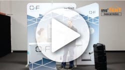 A large play button overlays an image of a person beside a display booth adorned with geometric patterns. The booth features a counter and nearby case, while the words instent and industries hover in the top right corner, highlighting their innovative booths.