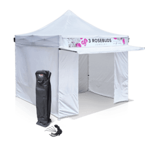 A white pop-up tent with the branding 3 Rosebuds Jewelry on the valance. The tent is set up with walls partially open. A carrying case is placed to the left of the tent.