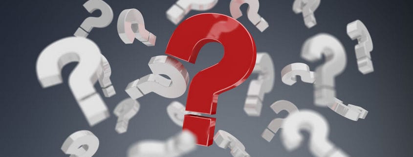 A large red question mark, complying with NFPA 701 standards, stands surrounded by multiple white question marks on a dark, blurred background.