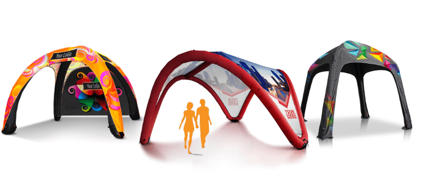 Three vibrant inflatable tents with artistic designs stand on a pristine white background. A silhouette of a person strolling is perfectly positioned in front of the red tent, capturing the essence of movement and color.