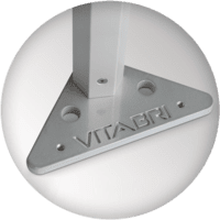 Close-up of a triangular metal bracket with holes, attached to a vertical pole. The word VITABRI is engraved on the bracket, which forms part of the custom trade show tents' sturdy framework. The background is white and blurred.