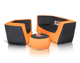 A modern furniture set perfect for a trade show booth, featuring an orange and black armchair, a matching loveseat, and a round ottoman with a black top and orange base. The pieces boast a sleek, contemporary design and are arranged closely together for maximum impact.