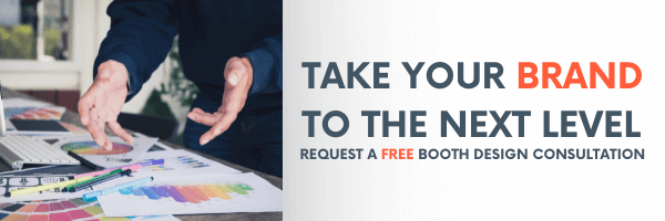 A person gestures over color swatches and a tablet; text reads Elevate your brand to the next level. Request a free trade show booth design consultation.