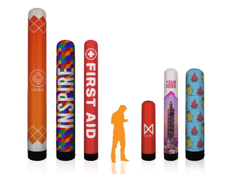 Six colorful inflatable air towers with diverse designs and text, including LOGO, INSPIRE, FIRST AID, and YOUR LOGO HERE, are arranged in a line. Each tower features vibrant patterns and emblems.