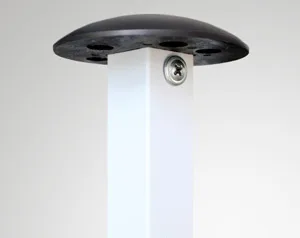Close-up of a white rectangular pole with a black circular cap on top, resembling the sturdy frame of a 10 x 10 canopy. There are four circular indentations and a visible screw on the side of the pole, set against a plain background.