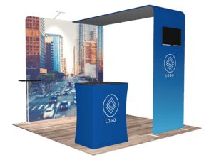Introducing the 10'x10' Quick-N-Fit Booth - Package #1102, designed with a sophisticated blue color scheme and a stunning cityscape backdrop. This booth includes both a counter and display stand, each adorned with a sleek geometric logo. The setup features a modern design complete with a screen placeholder positioned above for an enhanced visual experience.
