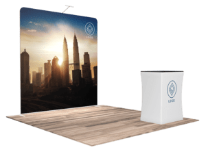 Experience the 10'x10' Quick-N-Fit Booth - Package # 1107, featuring a striking large backdrop showcasing a city skyline at sunset and a compact stand in front, both adorned with a generic logo. The entire booth is elegantly arranged on a wooden floor platform.