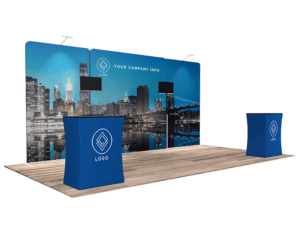 10'x20' Quick-N-Fit Booth - Package # 1209, designed with blue and white branding, includes a large backdrop depicting a city skyline at night. Two counters, each adorned with a logo, are positioned in front of the backdrop displaying the text "Your Company Info.
