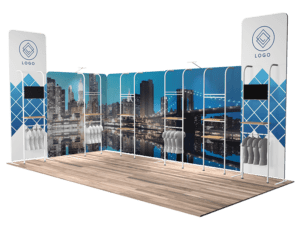 Introducing the 10'x20' Quick-N-Fit Booth - Package #1220, featuring a cityscape backdrop with modern buildings. This booth includes a sophisticated wooden floor, two tall banner displays for logos, shelves to showcase your products, and dual screens for enhanced engagement.