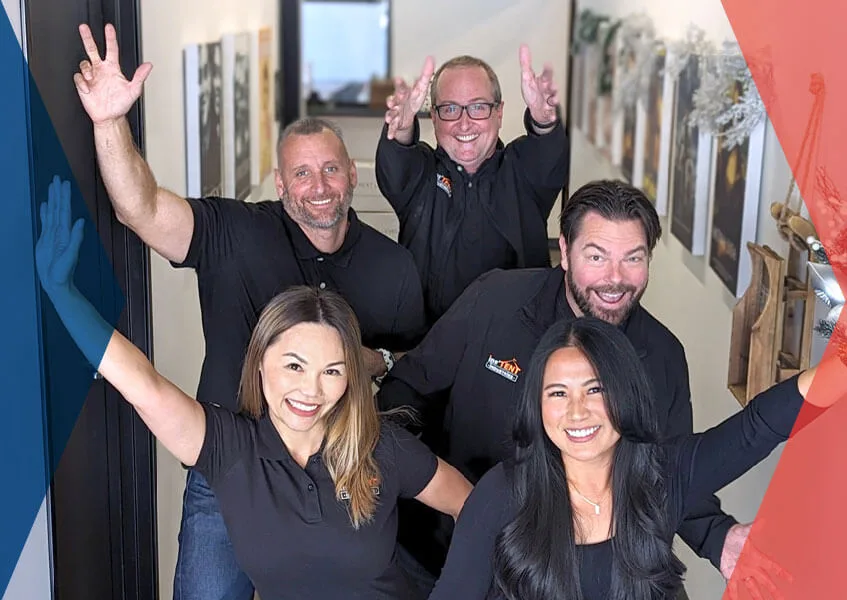 A group of five people in black shirts enthusiastically pose with their arms raised, smiling in a hallway. The image has a red and blue gradient border.