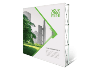 A 10x8 Printed Pop-Up Wall - Straight showcases a cityscape with greenery, featuring Your Logo Here in green. Below is placeholder text for company info, complemented by angular green accents on a metal framework.