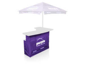 A portable promotional kiosk with Printed Bar Skirt Fabric Only, purple fabric, a white logo and text including purple. It includes a flat black countertop and a purple canopy acting as an overhead umbrella.