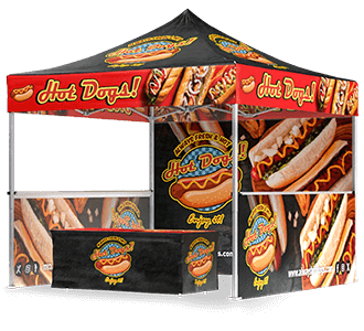 A colorful outdoor booth with a canopy and banners decorated with images of hot dogs and the words Hot Dogs! in bold, red letters, promoting a hot dog stand or vendor.