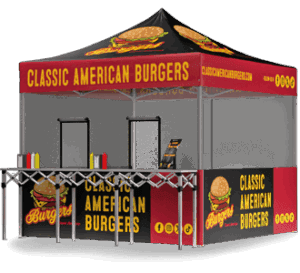 A pop-up food stall with a black and red canopy and banners reading Classic American Burgers, decorated with burger graphics. The stall has counters for serving food and condiment bottles on display.