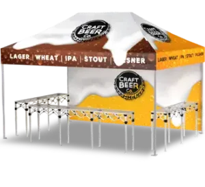 A pop-up tent with a yellow and white canopy featuring the words Craft Beer Co. and names of different beer types such as lager, wheat, IPA, and stout, with metal tables set up underneath.