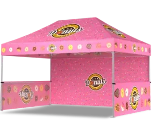 A pink canopy tent decorated with colorful donuts and donut-themed logos, designed for a donut stand or food vendor. The background features sprinkles and various donut illustrations.