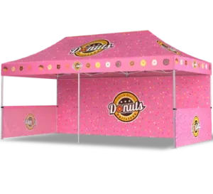 A pink pop-up tent decorated with colorful sprinkles and donut graphics, featuring a large Donuts logo on the front and side panels.