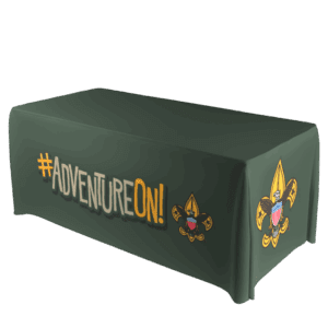 A green tablecloth with #ADVENTUREON! printed in bold letters and the Boy Scouts of America fleur-de-lis logo on the front and side.
