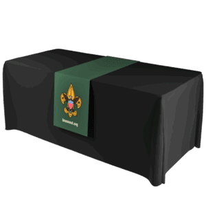 A black table covered with a green table runner featuring the Boy Scouts of America emblem and the text beascout.org on the front.