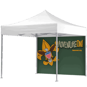 A white canopy tent with a green backdrop featuring the Boy Scouts of America emblem, the hashtag #ADVENTUREON!, and the website beascout.org.