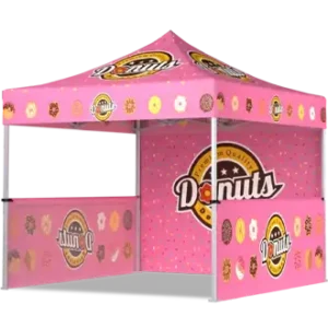 A pink pop-up food vendor tent with Donuts branding, donut images, and sprinkles printed on the canopy and fabric walls, designed as a booth for selling or promoting donuts.