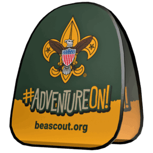 A foldable sign displays the Boy Scouts of America logo, the phrase #ADVENTUREON! in bold letters, and the website beascout.org on a green and yellow background.