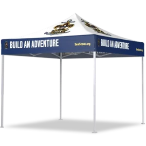 A white and navy blue pop-up canopy tent with BUILD AN ADVENTURE and SeaScout.org printed on the sides, and a pirate-themed logo on the roof.