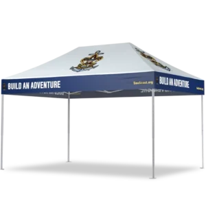 A white outdoor canopy tent with a blue border featuring the text BUILD AN ADVENTURE and an anchor logo. The tent has four metal legs and is labeled with SeaScout.org on the side panels.