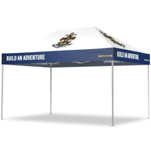 White canopy tent with a blue border along the edges displaying the text BUILD AN ADVENTURE. The top features a nautical anchor and compass logo, and the tent has four silver legs.