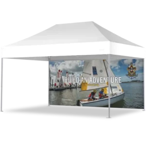 A white outdoor canopy tent with side panels featuring an image of sailboats on the water, scouts in life jackets, the Sea Scouts logo, and the text BUILD AN ADVENTURE and SeaScout.org.