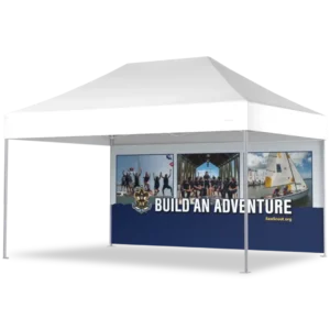 A white outdoor canopy tent with Build an Adventure and the Sea Scouts logo on the side panel, featuring images of people sailing and celebrating under a boat dock.