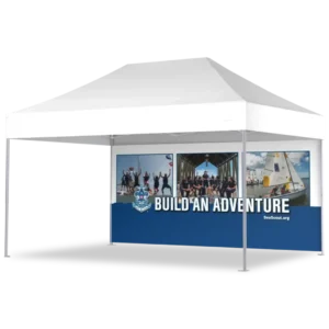A white outdoor canopy tent with a blue banner featuring the Sea Scouts logo, photos of sailing and group activities, and the text BUILD AN ADVENTURE with the website SeaScout.org.