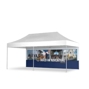 A white outdoor canopy tent with a banner displaying BUILD AN ADVENTURE and images of people participating in various activities, including sailing and group outdoor events.