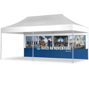 A white canopy tent with a blue and white banner that reads Build An Adventure and features photos of youth participating in various outdoor and boating activities.