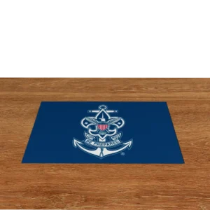 A blue mat with the Boy Scouts of America Sea Scouts emblem, featuring an anchor, eagle, shield, and the words “Be Prepared,” is placed on a wooden surface with a black background.