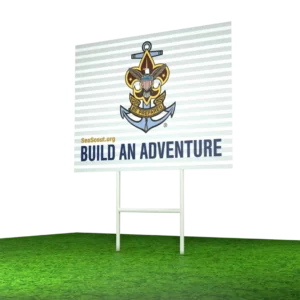 A billboard on grass displays the Sea Scout emblem, the words “SeaScout.org,” and the slogan “Build an Adventure.” The background is white with horizontal lines.