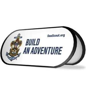 A white sign displays the Sea Scouts logo, the text BUILD AN ADVENTURE, and the website SeaScout.org in dark blue letters.