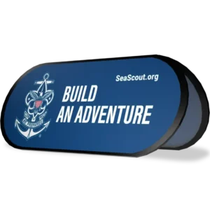 A blue display sign with the Sea Scouts logo, the words Build An Adventure, and the website SeaScout.org in white text.