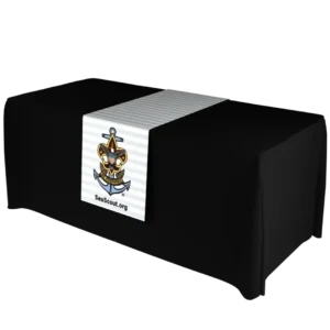 A rectangular table covered with a black tablecloth features a white table runner displaying the Sea Scout logo—an anchor with a fleur-de-lis and a ship’s wheel—and the URL SeaScout.org.