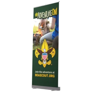 A vertical sign displays #ADVENTUREON! above an image of people sitting by a campfire. The Boy Scouts of America logo is below, with text: Join the adventure at BEASCOUT.ORG on a dark green background.