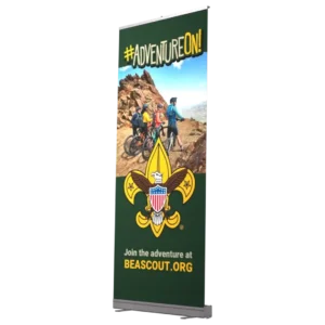 A display with #ADVENTUREON! at the top, an image of kids biking on a rocky trail, the Boy Scouts fleur-de-lis emblem, and the text Join the adventure at BEASCOUT.ORG at the bottom.