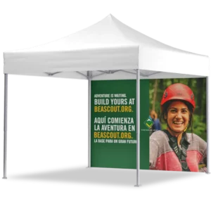 A white canopy tent with a side panel displaying a smiling young person in outdoor gear and helmet. Text on the panel reads Adventure is waiting. Build yours at BEASCOUT.ORG. in English and Spanish.