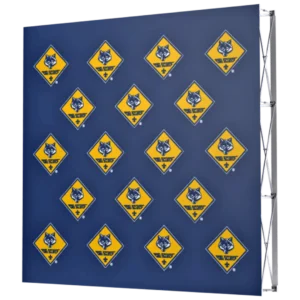 A blue display backdrop featuring a repeating pattern of yellow diamond-shaped signs with a wolf logo and the words Wolf Scouts and a fleur-de-lis symbol.