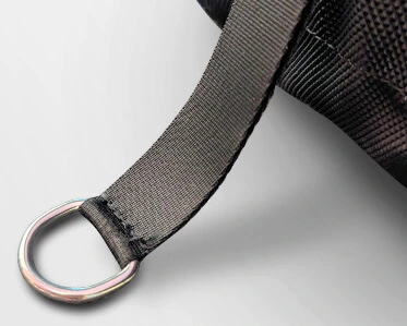 A close-up of a gray fabric strap with a silver metal D-ring, attached to a textured black bag.