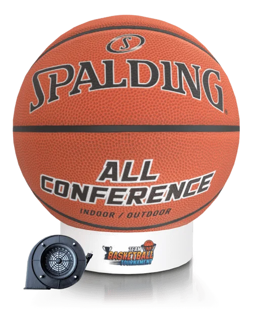 A Spalding basketball labeled All Conference Indoor/Outdoor sits atop a white display stand with a small fan and a Team Basketball Tournament graphic.