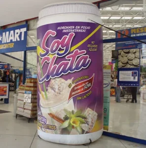 A large inflatable replica of a Soy Chata horchata powder container stands at the entrance of a supermarket, with shoppers and store signs visible in the background.