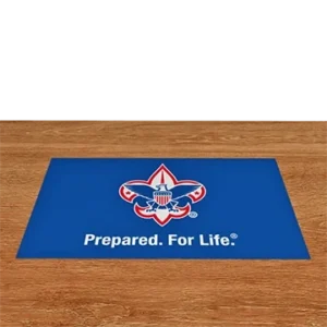 A blue mat with the Boy Scouts of America logo and the words Prepared. For Life. sits on a wooden floor.